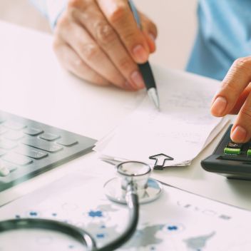 Arzt notiert Infos auf Papier